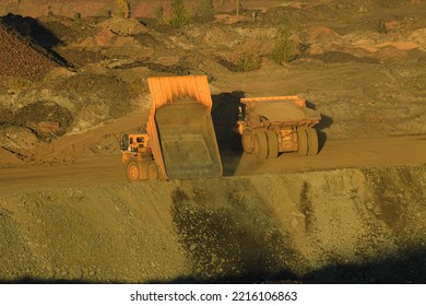 The Process Of Unloading A Large Dump Truck That Carries Minerals. The Technology Of Ore Mining, Raw Materials For Metallurgy.