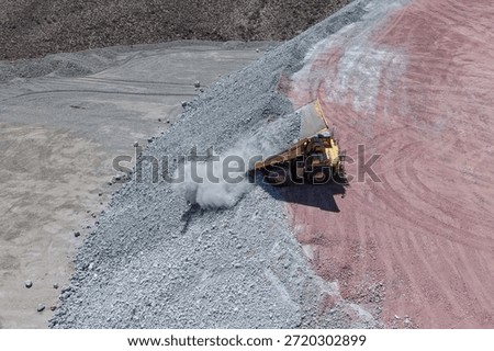 Process of unloading waste materials at mine dumps using giant mining trucks