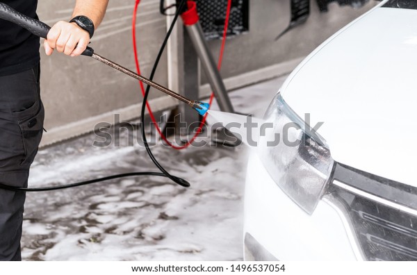 The process of\
washing the headlights of a car with the help of a pressure washer\
on a self-wash car wash
