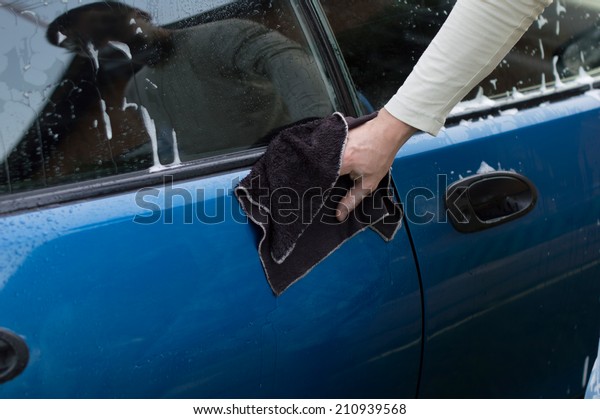 The process of washing and wiping cars with the help\
of a cloth in the yard