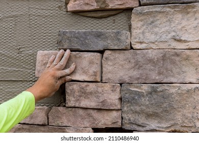 Process Of Worker Laying Decorative Bricks Stone On The Wall.