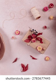 Process of wrapping and decorating presents with dried flowers. Gift boxes in craft paper and natural autumn decorations, creative and zero waste holidays present wrapping. DIY concept