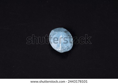 Processed aquamarine, prepared for jewelry. Precious semitransparent stone on a dark background.