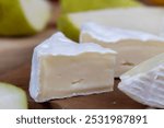 processed cheese with white mold close-up, fresh cheese on a cutting board