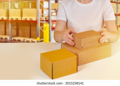 Processing order concept. Cardboard boxes in front of man. Man hands are packing something. Warehouse worker processing order. Order fulfillment process. Preparation of warehouse goods for shipment