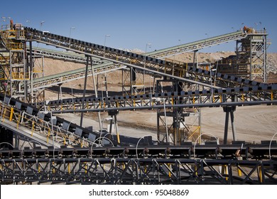 Processing Plant Lithium Mine in Western Australia. Mechanical processing used to refine lithium spodumene concentrate. Multiple conveyor belts cross into distance.