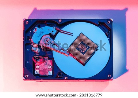 processing unit CPU microprocessor chip placed on opened computer hard disk drive HDD components as a conceptual metaphor for AI hardware semiconductor technology data storage infrastructure and cyber