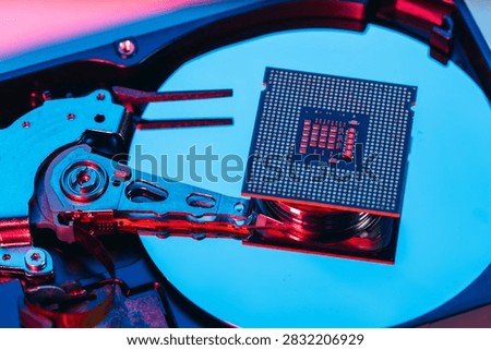 processing unit CPU microprocessor chip placed on opened computer hard disk drive HDD components as a conceptual metaphor for AI hardware semiconductor technology data storage infrastructure and cyber