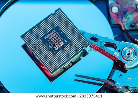 processing unit CPU microprocessor chip placed on opened computer hard disk drive HDD components as a conceptual metaphor for AI hardware semiconductor technology data storage infrastructure and cyber