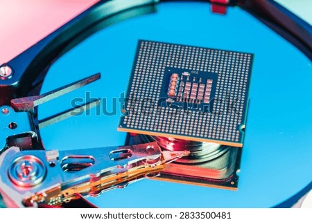 processing unit CPU microprocessor chip placed on opened computer hard disk drive HDD components as a conceptual metaphor for AI hardware semiconductor technology data storage infrastructure and cyber