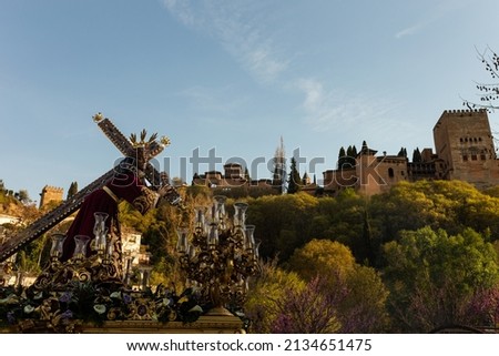 Procession of holy week in granada next to the alhambra. Place of vacations to enjoy the tourism in spain in vacations. Jesus carrying the cross.