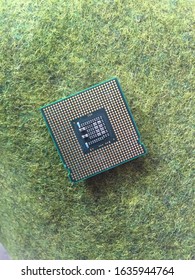 Processor Chip Above The Green Grass. Used As The Central Brain Of A Machine On A Computer Or PC