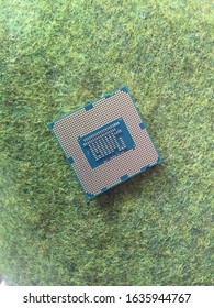 Processor Chip Above The Green Grass. Used As The Central Brain Of A Machine On A Computer Or PC