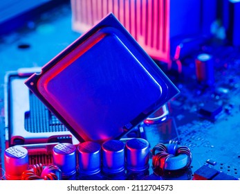 The processor, microprocessor lies on the motherboard of a personal computer with the contacts up. Neon lighting. Technological background. Computer components.
