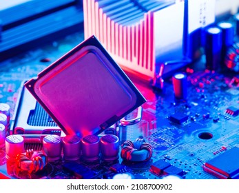 Processor with open cover on the motherboard of a personal computer. High computer technology, digital equipment, computer equipment repair, communications. Neon lighting. Technological background.