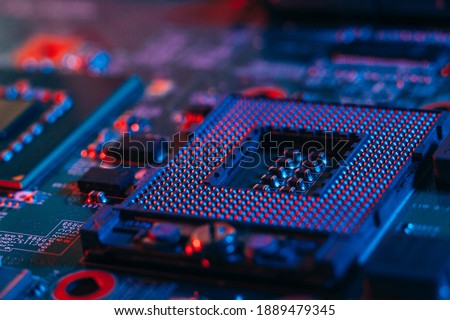 Processor socket in neon light. Motherboard with microchips. Dark photo.CPU processor.PC components.