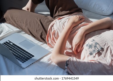 Procrastination, Rest From Work: A Woman Rests In Bed Next To A Computer. Concept Of Remote Work, Not Being Able To Be Productive, Being Lazy Working From Home