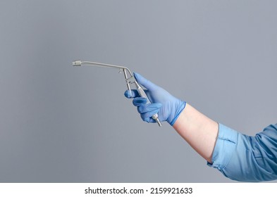 Proctology. Doctor's hand in medical glove holds medical instruments to treat patient.