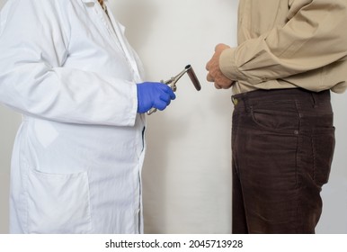 Proctology rectal mirror in hands of doctor.Man take the stomach.  White smock .Blue gloves.