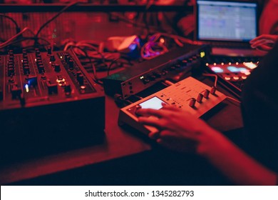 producer  DJ mixer in a nightclub with glowing plays musical rave Dubstep Electronic Trance composition with modern midi controller device in nightclub Live.Musical production process for artists.