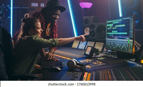 Producer and Professional Audio Engineer Working together in Music Recording Studio on a New Album, Talk, Use Control Desk Equalizer, Mixing Board and Software to Create Hit Song. Artist and Musician - Powered by Shutterstock