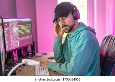 Producer working in sound design studio. music, film score, advertising footage digital editing, jingle song, voice actor recording, post production. Young man working with his computer. Home work
