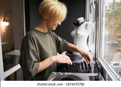 Producing and mixing modern style beats music. Side view of the woman beat making and arranging audio content with software controllers and digital effects processors