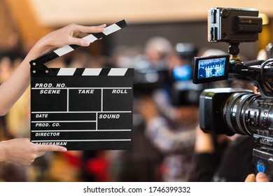 Producing Movies, Clapper Board With People On The Background.