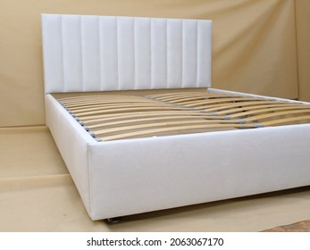 Production. Bed Upholstered In White Fabric Without Mattress. Wooden Slats.