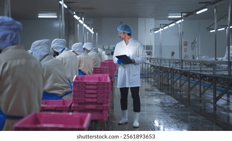 Production control supervisor inspects and controls the operation of each step in the production line of a canned fish factory