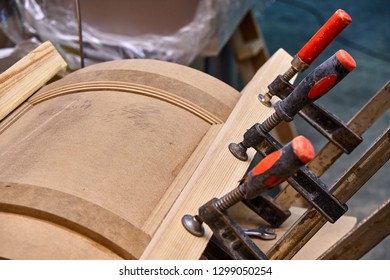 Production Of Curved MDF Cabinet Doors. Metal Clamps Tightening Mdf Details. Wooden Furniture Manufacturing Process