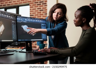 Production department team leader indicating mesh geometry glitch and giving solution to coworker. 3D digital artist collaborating with colleague in order to solve technical difficulties.