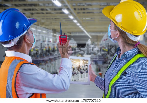Production engineers holding tablet\
and talking communication in process line and planing setting new\
machine system in production line of manufacturer\
factory