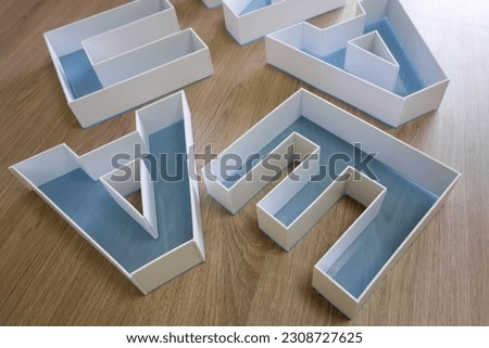 Production of letters of the company name in the production of outdoor advertising.Plastic letters made of PVC plastic are lying on the table.