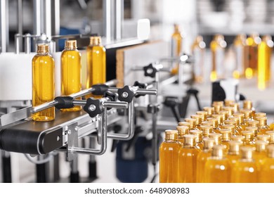 Production Line Of Beauty And Healthcare Products At Plant Or Factory. Process Of Manufacturing And Packaging Cosmetics Goods. Glass Or Plastic Bottles With Screw Caps Standing On Conveyor Belt