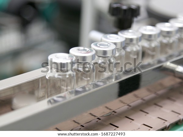 Production line with glass ampoules and medicine at\
the factory. Pharmaceutical industry. Development of cures for the\
virus
