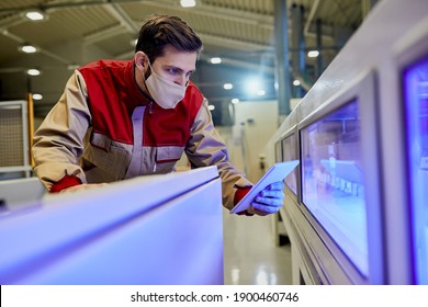 Production line operator using digital tablet while supervising automated machine at woodworking factory during coronavirus pandemic. - Powered by Shutterstock - Get 15% off with code: PIKWIZARD15