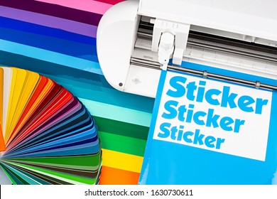 production making sticker with plotter cutting machine on sheets of colorful various rainbow colored vinyl fim with color fan. guide. Advertising Industry diy design concept background.