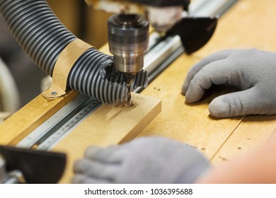 production, manufacture and woodworking industry concept - hands of carpenter working with drill press and board at workshop - Powered by Shutterstock