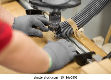 production, manufacture and woodworking industry concept - hands of carpenter working with drill press and board at workshop - Powered by Shutterstock