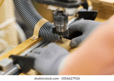 production, manufacture and woodworking industry concept - hands of carpenter working with drill press and board at workshop - Powered by Shutterstock