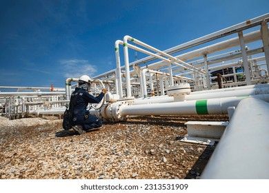 Production operator opening ball valve at pipeline oil and gas wellhead remote platform to control gases and crude oil process petroleum industry. - Shutterstock ID 2313531909
