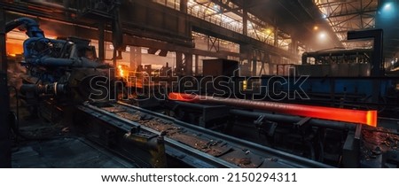 Production process of cast iron water pipes at industrial steel mill. Metallurgical foundry factory with press forming machines for manufacturing tubing. Heavy industry interior background