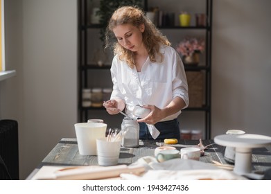 Production process of pottery. Application of glaze brush on ceramic ware. - Powered by Shutterstock