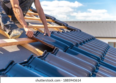 production of roofs from ceramic fired tiles on a family house - Shutterstock ID 1885943614