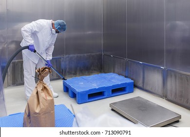 Production room in the medical laboratory. A specialist in protective clothing and a mask makes cleaning of a sterile room.