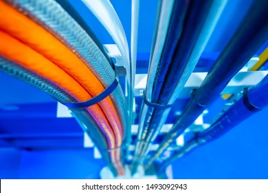 Production wiring. Electrical wiring in technical rooms. Electric wires are fastened by a plastic coupler. Cable wiring. Network engineering. Orange and deep blue electric wires.Work as an electrician