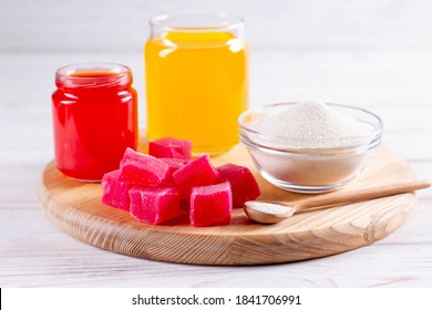 Products (collagen powder, gelatin) which contain collagen. Colored gelatin or marmalade. Collagen powder on a light background.