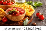 Products for cooking - tomato sauce, pasta, tomatoes, garlic, olive oil on the old wooden background.