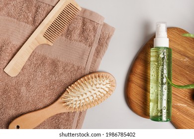 Product's For Daily Hair Care. Comb, Shampoo Or Lotion, Towel On Gray Background Top View